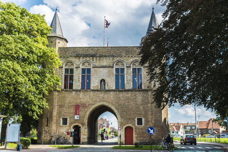Bruges, Belgium, - August 31, 2017: Gentpoort (Gate of Ghent) with people circulating on bike in the medieval city of Bruges, Belgiumのeditorial素材