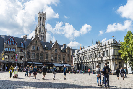 Bruges, Belgium, - August 31, 2017: Architectural ensemble in the Burg square with restaurants and people walking and The Belfry of Bruges in the background in the medieval city of Bruges, Belgiumのeditorial素材