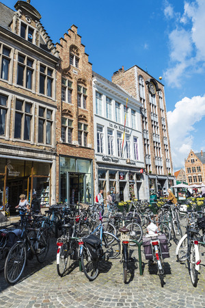 Bruges, Belgium - August 31, 2017: Lots of parked bicycles and people walking on a street in the medieval city of Bruges, Belgiumのeditorial素材