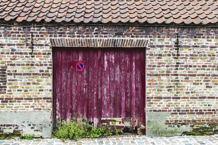 Wooden door of an old abandoned building in an old historic center of the medieval city of Bruges, Belgiumの写真素材