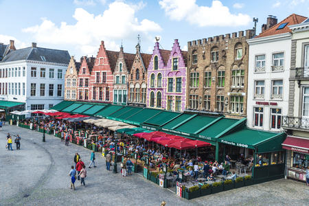 Bruges, Belgium - August 31, 2017: Old colorful traditional houses with bars and restaurants in the Grote Markt ( Market Square ) with people around in the historic center of the medieval city of Bruges, Belgiumのeditorial素材