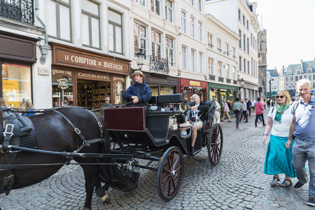 Bruges, Belgium - August 31, 2017: Carriage with horse carrying tourists on a street in the historic center of the medieval city of Bruges, Belgiumのeditorial素材