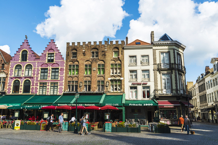 Bruges, Belgium - August 31, 2017: Old colorful traditional houses with bars and restaurants in the Grote Markt ( Market Square ) with people around in the historic center of the medieval city of Bruges, Belgiumのeditorial素材