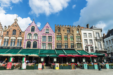 Bruges, Belgium - August 31, 2017: Old colorful traditional houses with bars and restaurants in the Grote Markt ( Market Square ) with people around in the historic center of the medieval city of Bruges, Belgiumのeditorial素材