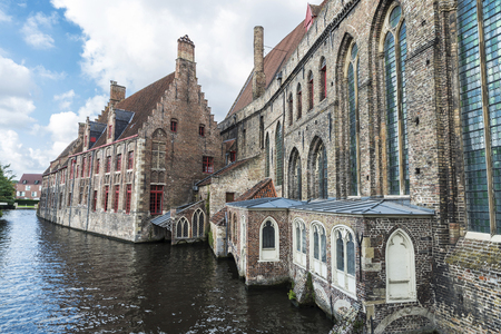 Old traditional houses along the river in the medieval city of Bruges, Belgiumの写真素材