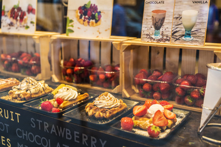 Bruges, Belgium - September 1, 2017: Display of a candy shop full of waffles with fruits like blackberries or strawberries in the medieval city of Bruges, Belgiumのeditorial素材
