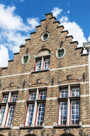 Facade of old historic buildings in the medieval city of Bruges, Belgiumの写真素材