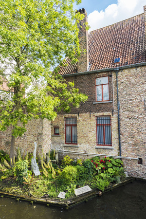 Bruges, Belgium - September 1, 2017: Old traditional house with a small garden along the river in the medieval city of Bruges, Belgiumのeditorial素材
