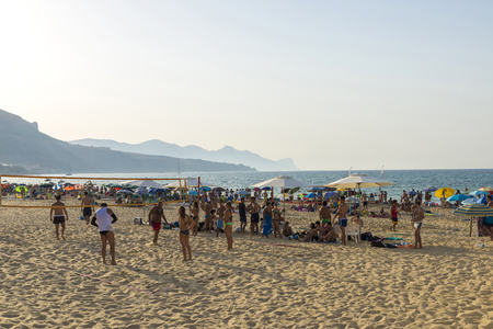 Castellammare del Golfo, Italy - August 6, 2017: Beach full of bathers in summer and young people playing volleyball in Castellammare del Golfo in Sicily, Italyのeditorial素材