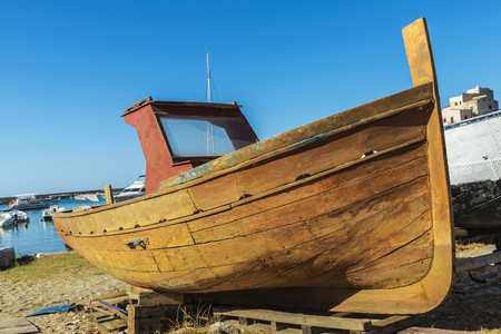 Old wooden fishing boat moored on the beach in summer in Castellammare del Golfo in Sicily, Italyの写真素材