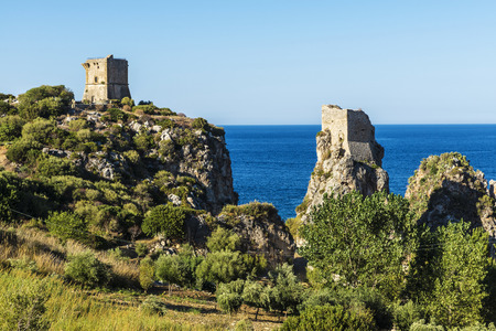 Cliffs on the coast with medieval turrets of a castle in summer in Scopello near of Castellammare del Golfo in Sicily, Italy の写真素材