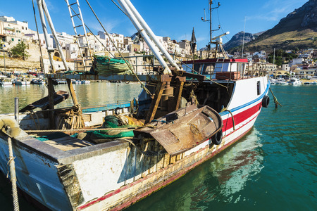 Fishing port with old wooden fishing boats docked at the marina in summer in Castellammare del Golfo in Sicily, Italyの写真素材