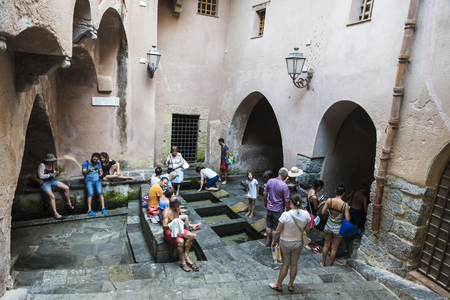 Cefalu, Italy - August 8, 2017: Lavatoio, a medieval laundry, with people around in the old town of the historic village of Cefalu in Sicily, Italyのeditorial素材