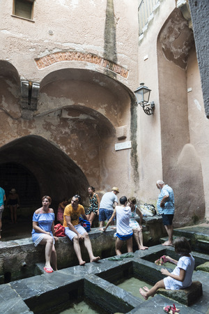 Cefalu, Italy - August 8, 2017: Lavatoio, a medieval laundry, with people around in the old town of the historic village of Cefalu in Sicily, Italyのeditorial素材