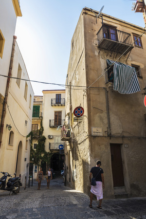 Cefalu, Italy - August 8, 2017: Narrow street of the old town with people walking of the historic village of Cefalu in Sicily, Italyのeditorial素材