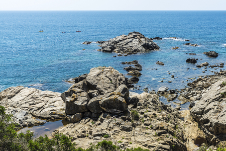 People practicing kayak next to cliffs with crystal clear water in Costa Brava, Girona, Catalonia, Spainの写真素材