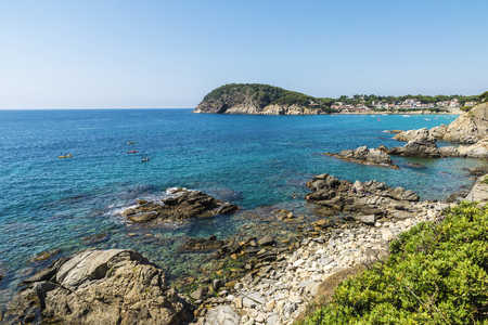 People practicing kayak next to cliffs with crystal clear water in Costa Brava, Girona, Catalonia, Spainの写真素材