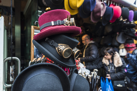 London, United Kingdom  - December 31, 2017: Hats and Gothic black sunglasses with diffracted lens or Kaleidoscope in a fashion shop of Camden Lock Market or Camden Town with people around in London, England, United Kingdomのeditorial素材