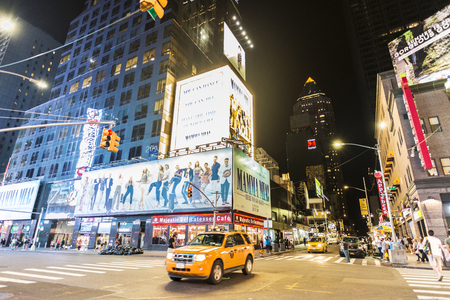 New York City, USA - July 30, 2018: Taxi and shops at night on Seventh Avenue (7th Avenue) next to Times Square with people around and large advertising screens in Manhattan in New York City, USAのeditorial素材