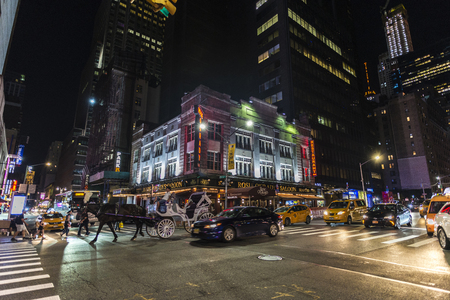 New York City, USA - July 30, 2018: Horse carriage at night on Seventh Avenue (7th Avenue) next to Times Square with people around in Manhattan in New York City, USAのeditorial素材
