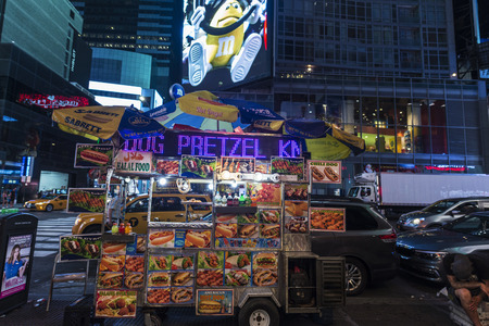 New York City, USA - July 30, 2018: Food truck on Times Square at night with a man resting and large advertising screens in Manhattan in New York City, USAのeditorial素材