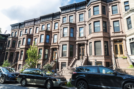 Old typical houses with cars parked in the Brooklyn neighborhood in Manhattan, New York City, USA