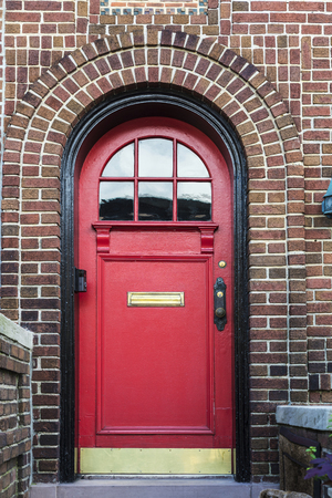 Classic red door of an old typical house in the Brooklyn neighborhood in Manhattan, New York City, USAの写真素材