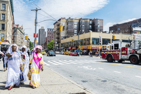 New York City, USA - July 28, 2018: Three black women with typical dresses walking on a street in...