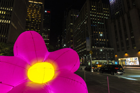 New York City, USA - July 30, 2018: 47-50 Streets Rockefeller Center Station at night on Sixth Avenue (6th Avenue) with a giant pink plastic flower in Manhattan in New York City, USAのeditorial素材
