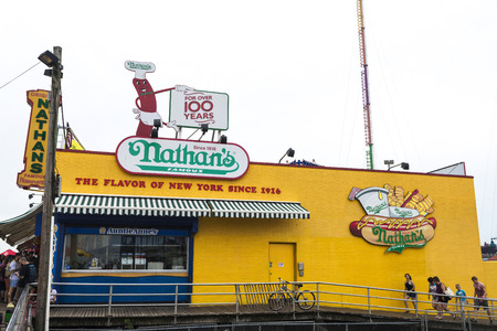 New York City, USA - July 30, 2018: Restaurant called Nathans at the Luna Park amusement park with people walking on the promenade of Coney Island Beach, Brooklyn, New York City, USAのeditorial素材