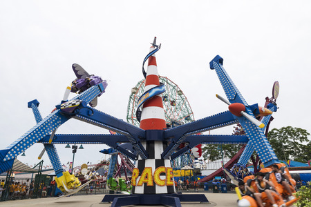 New York City, USA - July 30, 2018: Luna Park amusement park on summer with people in the rotating attraction that goes around in Coney Island Beach, Brooklyn, New York City, USAのeditorial素材