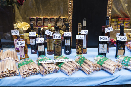 Cardona, Spain - October 30, 2016: Bottles of muscatel and handmade neules, a type of Catalan biscuit eaten traditionally in Christmas with cava (Catalan champagne), in the shop window of a pastry shop in Cardona, Catalonia, Spainのeditorial素材