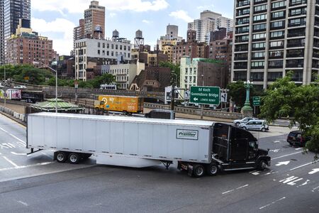 New York City, USA - July 31, 2018: White and heavy truck with container circulating on a street in front of Queensboro Bridge in New York City, USAのeditorial素材