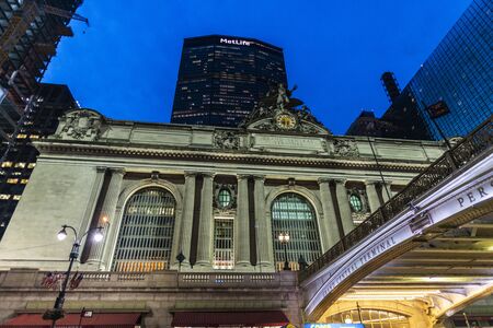 New York City, USA - August 1, 2018: Facade of the Grand Central Terminal, commuter rail terminal, at night with the MetLife Building in the background located in Midtown Manhattan, New York City, USAのeditorial素材