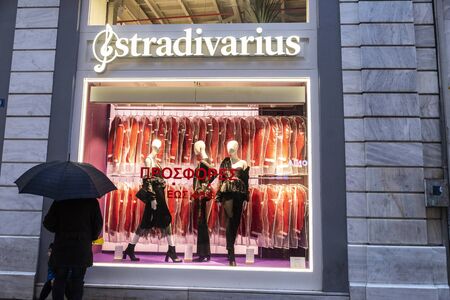Athens, Greece - January 4, 2019: Display of a Stradivarius store at night with people around in Athens, Greeceのeditorial素材