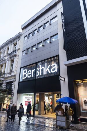 Athens, Greece - January 4, 2019: Display of a Bershka store at night with people around in Athens, Greeceのeditorial素材