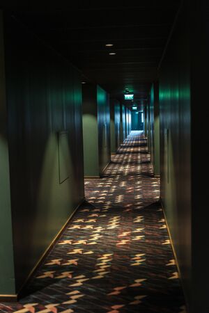 Dark, lonely and dark hallway with light at the end inside a modern building as backgroundの写真素材