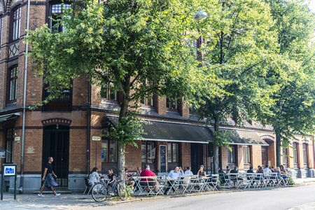 Malmo, Sweden - August 28, 2019: Street with a bar terrace and people around in Malmo, Swedenのeditorial素材