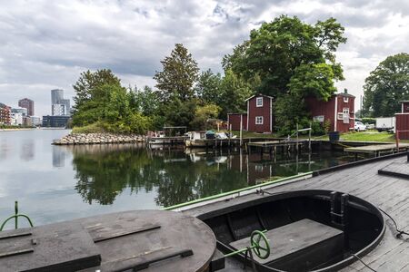 Pier with boats in Fiskehoddorna, traditional fish market on a street with the city of Malmo in the...