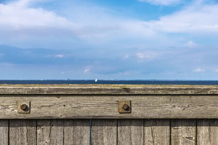 Wooden railing on a dike in front of the Baltic Sea as background in VÃ¤stra Hamnen, Malmo, Sweden の写真素材