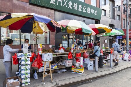 New York City, USA - August 2, 2018: Vendors in a flea market of fruit and vegetables on a street in Chinatown, Manhattan, New York City, USAのeditorial素材