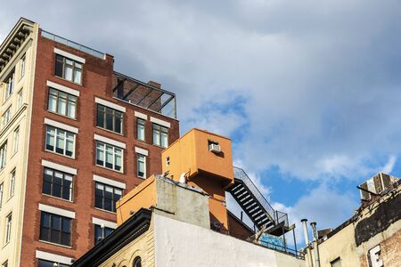 New York City, USA - August 2, 2018: Old apartment buildings with people around in Manhattan, New York City, USAのeditorial素材