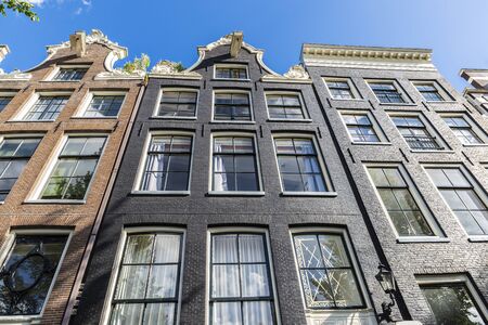 Facade of old traditional leaning houses in the old town of Amsterdam, Netherlands