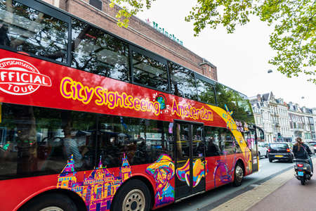 Amsterdam, Netherlands - September 8, 2018: Tour bus with tourists circulating with the Heineken factory in the background in Amsterdam, Netherlandsのeditorial素材