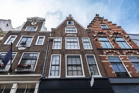 Facade of old traditional leaning houses in the old town of Amsterdam, Netherlandsの写真素材