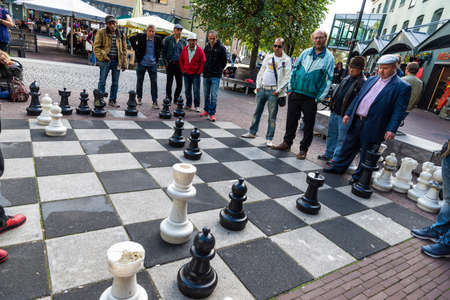 Amsterdam, Netherlands - September 9, 2018: People playing chess on a large chessboard built on the...