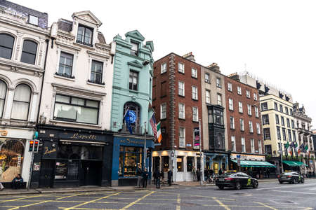 Dublin, Ireland - December 30, 2019: Dame Street with shops, restaurants, irish pub and people...