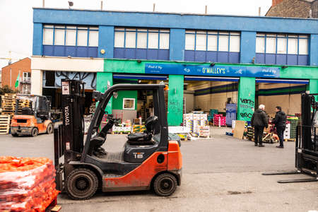Dublin, Ireland - December 30, 2019: Forklifts with pallets of fruit on a street in OMalley Brendan,...