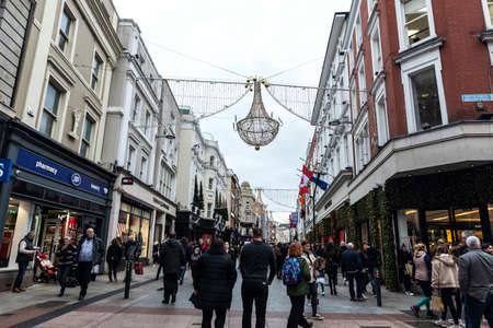 Dublin, Ireland - December 30, 2019: Grafton Quarter at night, shopping street with restaurants, shops, people around and Christmas decoration in the center of Dublin, Irelandのeditorial素材
