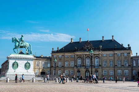 Copenhagen, Denmark - August 27, 2019: Equestrian statue of the King Frederick V and the facade of the Frederick VIII Palace (Brockdorff's Palace) with people around in Amalienborg Square, Copenhagen, Denmarkのeditorial素材